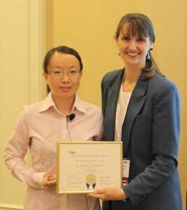 Lina Ma (left) receives the Kreidl Award from Kelly Simmons-Potter, chair of ACerS’ Glass and Optical Materials Division, for her work on the structure of phosphate glasses. Photo courtesy of ACerS.