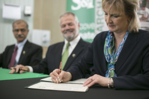 Missouri S&T Chancellor Cheryl B. Schrader joins Dr. K. Krishnamurthy, vice provost for research, in signing a master research agreement with Boeing's John Eash at Innovation Park. Sam O'Keefe/Missouri S&T
