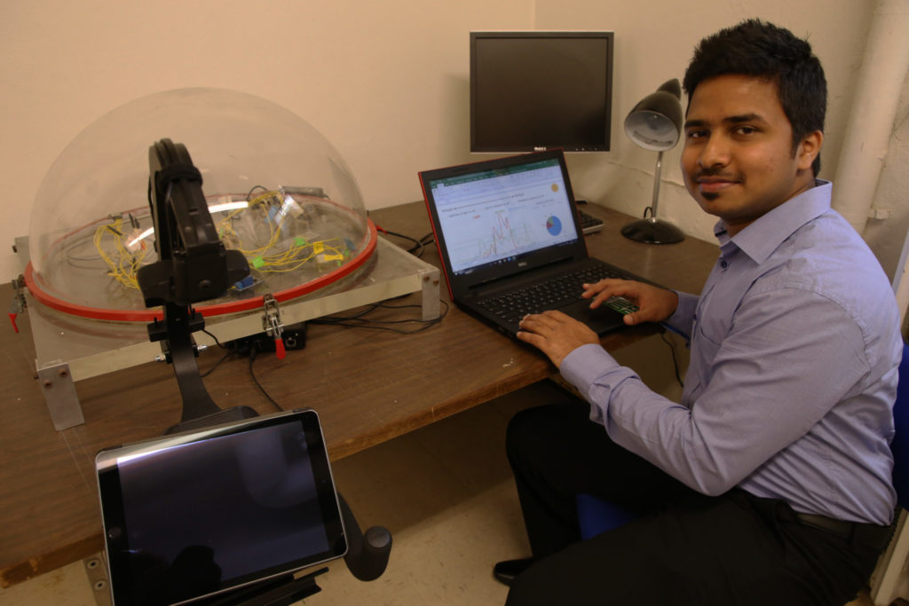 Yogesh Lad reviews data graphs next to an eye tracking device in Schrenk Hall.