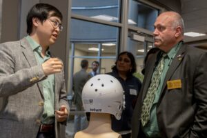 Dr. Jie Huang (left) discusses one of his "smart" helmet prototypes with Missouri State Rep. Don Mayhew. Photo by Tom Wagner, Missouri S&T.