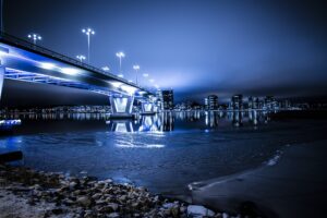 photo of bridge and city skyline at night