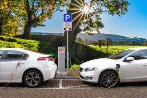 photo of white cars at an electric charging station