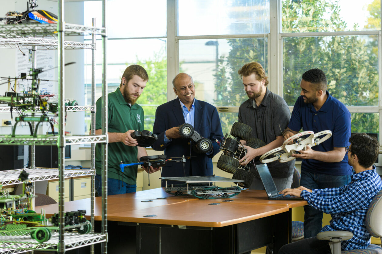 Photo of Dr. Sarangapani and students with robots in lab
