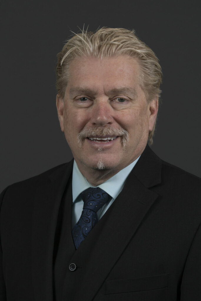 Photo of Dr. Jeffrey Cawlfield, who has a goatee and is wearing a dark suit, white shirt and blue tie.