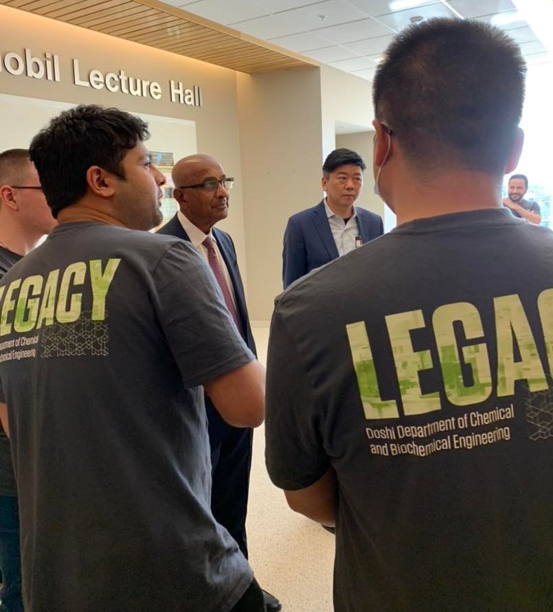 Students wearing t-shirts that read "Legay" gather around men in suits and ties