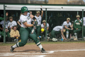 Woman in Missouri S&T softball uniform swings at the ball.