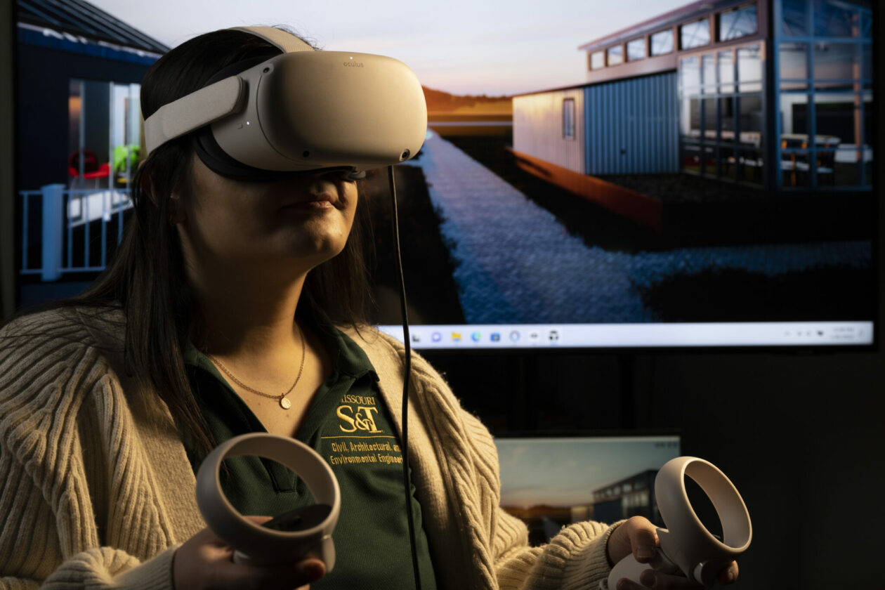 Mel Azimzadeh, a master’s student in civil engineering, uses an Oculus Quest 2 headset to tour the Missouri S&T Solar Village, shown behind her. Photo by Michael Pierce/Missouri S&T.