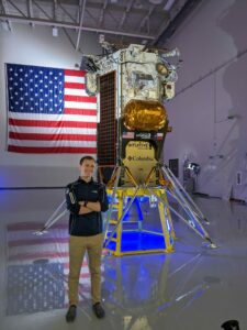 Matt Klosterman stands in front of the Odysseus spacecraft that recently landed on the moon.