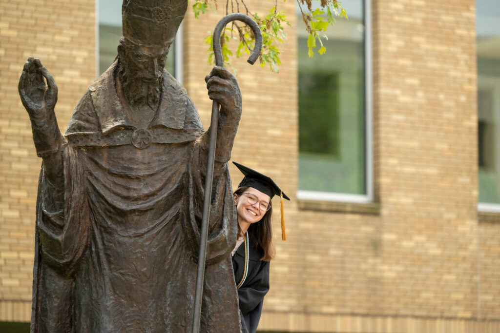 Lana Dizdarevic peeks from behind S&T's statue of Saint Patrick.