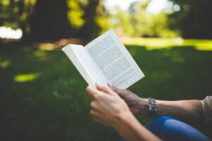 Hands holding a book outdoors