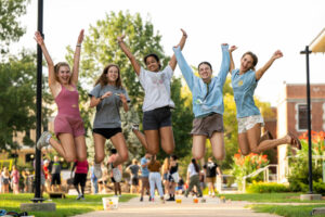 Five students jump during Party at the Puck.