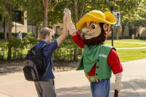 Joe Miner, S&T's mascot, gives a student a high five on the university's campus.