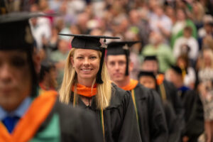 Woman graduate in focus in processional