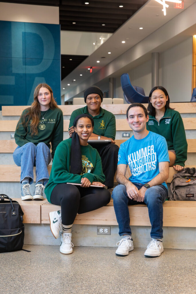 A group of students pose for a photo in the Innovation Lab Forum.