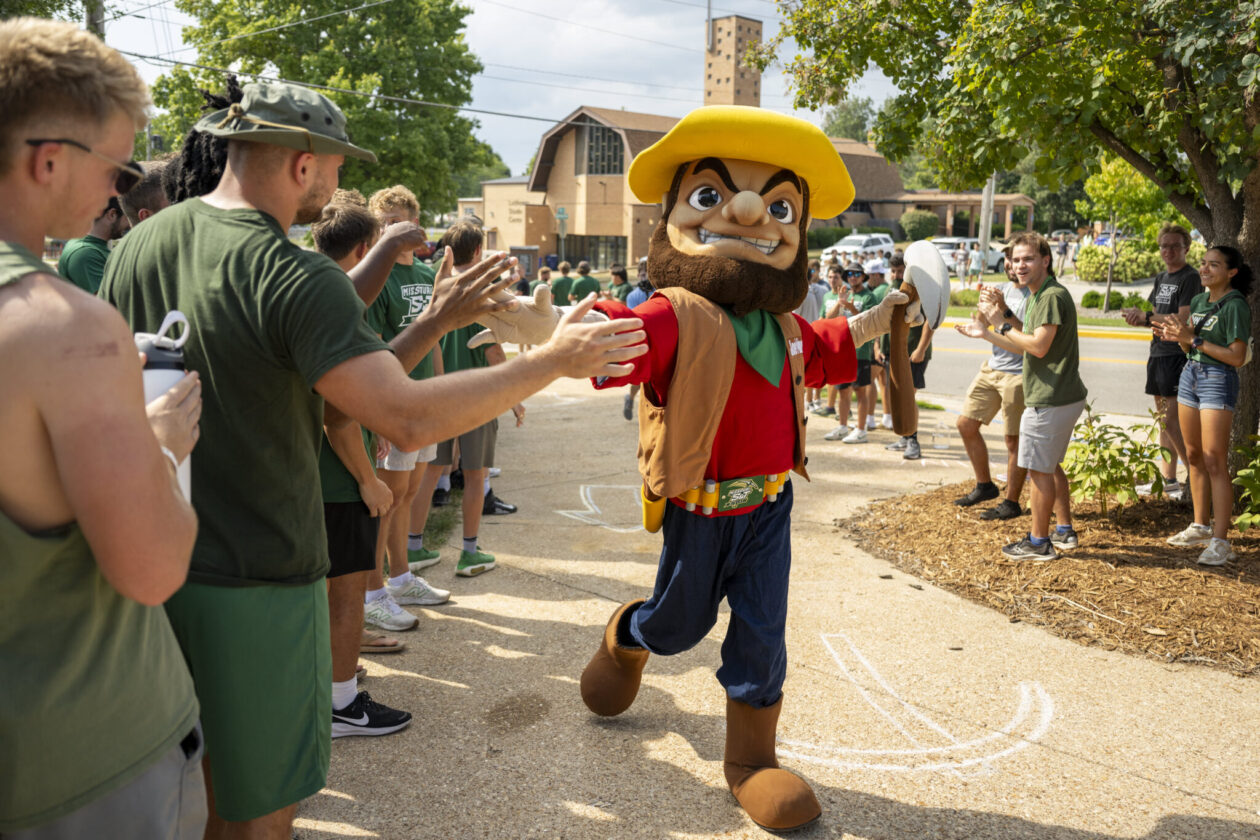 Missouri S&T mascot Joe Miner high-fives a line of students leading up to the fall 2025 convocation ceremony on Aug. 18. Photo by Michael Pierce/Missouri S&T.
