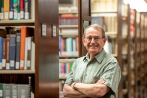 Dr. Larry Gragg standing in front of bookshelves in the Curtis Laws Wilson Library.