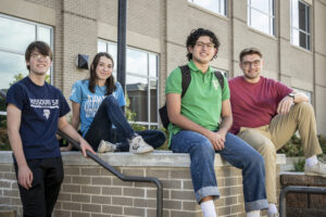 Four S&T students posing for a photo on an outdoor stairway on campus.