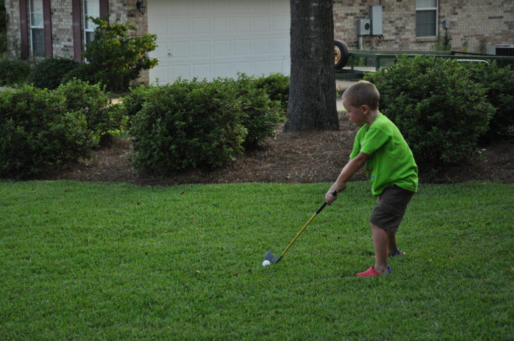 Cole Komyati playing golf as a child.
