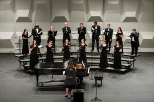 The S&T student choir performing on the stage at Leach Theatre, under the direction of Lorie Francis.