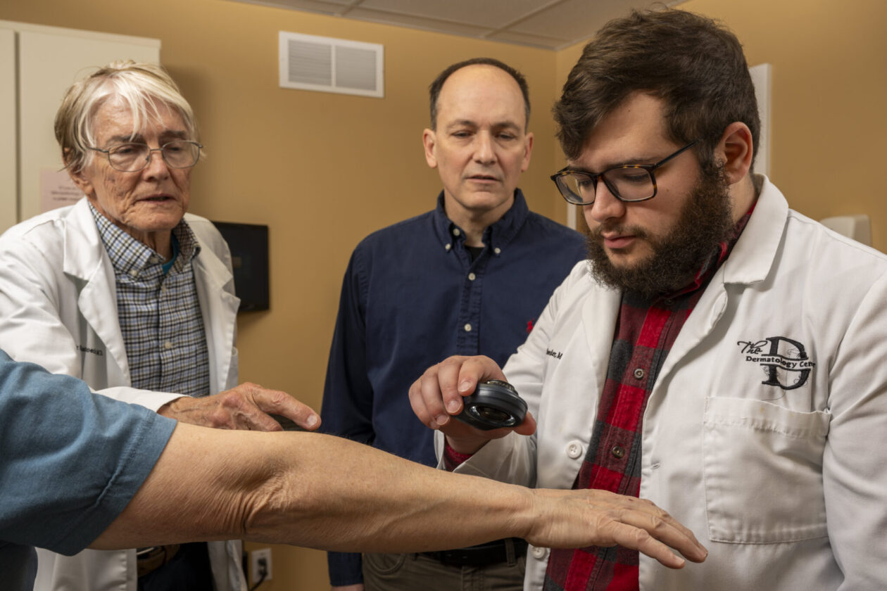 From left, Dr. William Stoecker, a dermatologist and alumnus of the University of Missouri School of Medicine; Dr. Joseph Stanley, a professor of electrical and computer engineering; and Joshua Rogge, a Ph.D. student in electrical engineering, discuss the signs of skin cancer in Stoecker’s Rolla clinic. Photo by Michael Pierce/Missouri S&T.