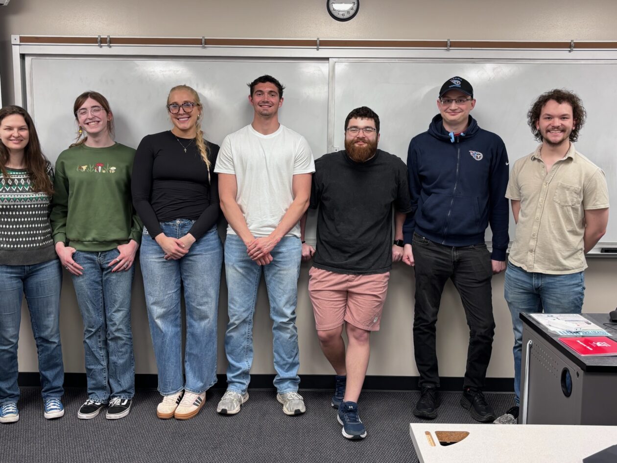 A group of students smile for the camera in a classroom at Missouri S&T.