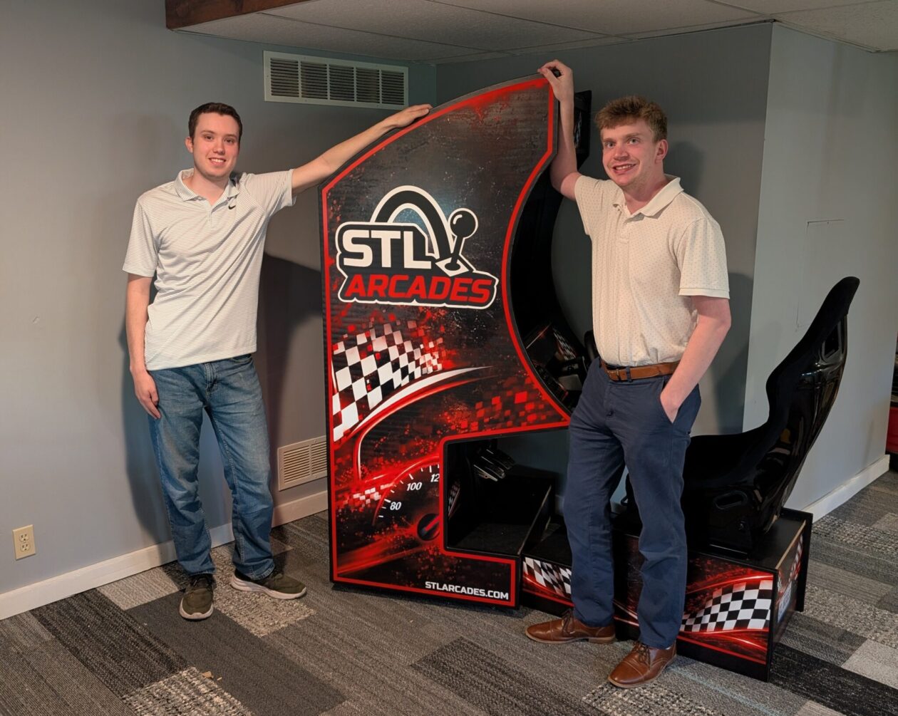 S&T alumni Ben Roth (left) and Gavin Hays (right) stand beside one of the customizable arcade machines.