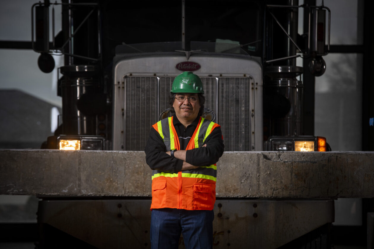 Dr. Mohamed ElGawady stands in front of a bridge girder and tractor trailer