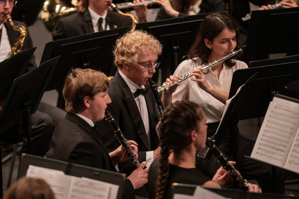 Students playing flute and clarinet onstage at Leach Theatre during a concert.