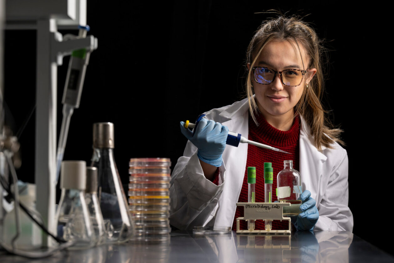 Woman working in laboratory holding piping device.