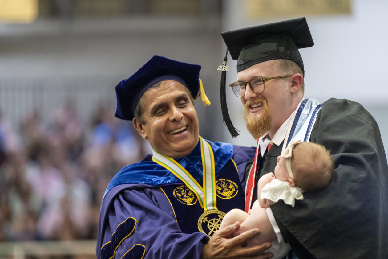 Maxwell and Milena Gessert celebrate on the commencement stage with S&T Chancellor Mohammad Dehghani. Photo by Michael Pierce/Missouri S&T
