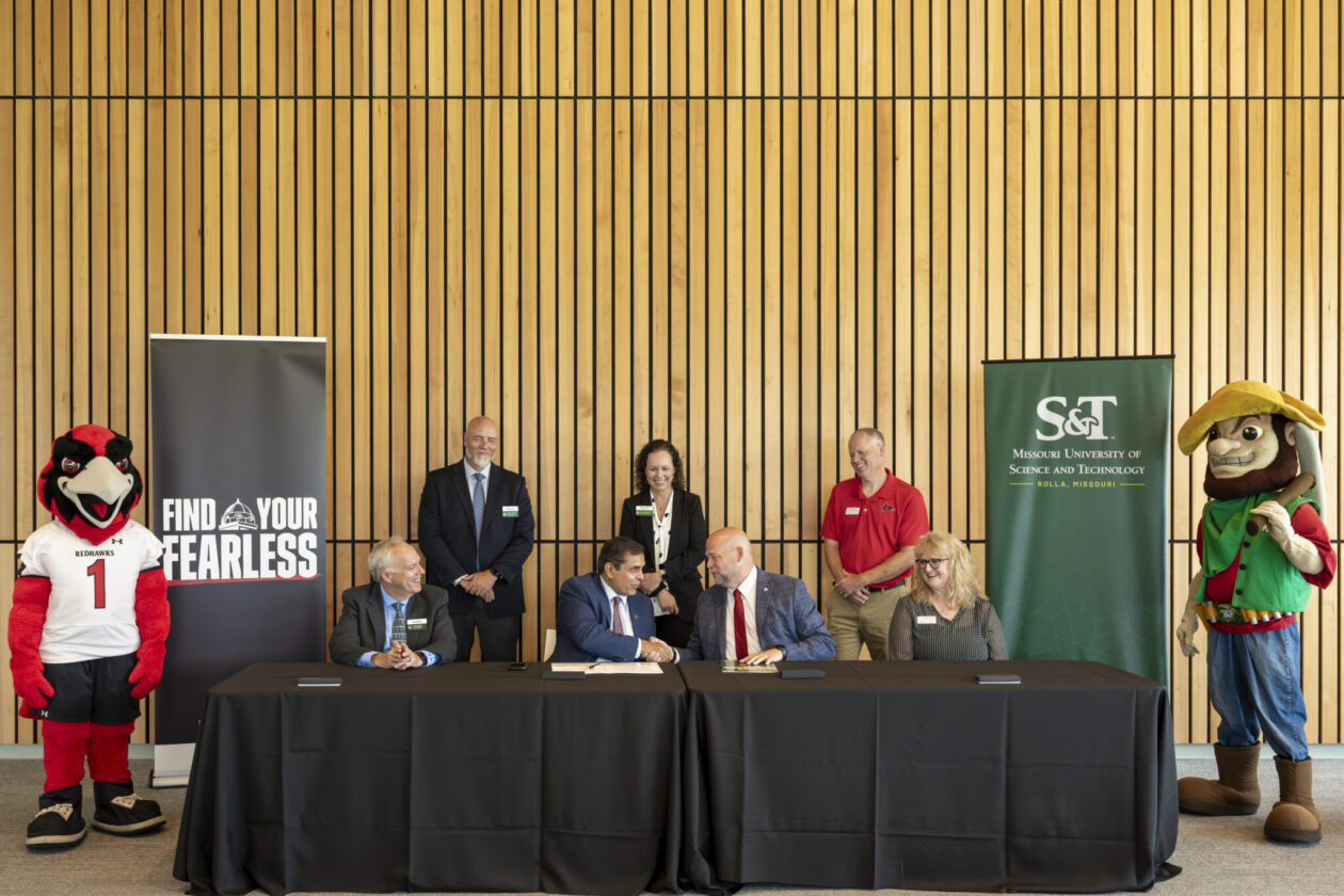 Rowdy the Redhawk and Joe Miner flank the signing table as Missouri S&T Chancellor Mohammad Dehghani and SEMO President Brad Hodson shake hands. Joining them in the front row are Dr. John Harris, S&T provost and executive vice chancellor for academic affairs, left, and Dr. Tamela Randolph, dean of SEMO's College of Science, Technology, Engineering and Mathematics. Standing in the back row are Dr. David Borrok, vice provost and dean of S&T's College of Engineering and Computing, Alysha O'Neil, S&T vice chancellor for finance and operations, and Dr. Brad Deken, SEMO's chair of engineering and technology. Photo by Michael Pierce/Missouri S&T