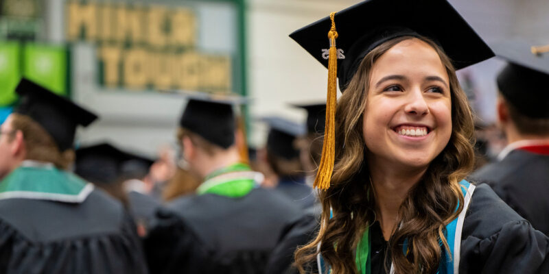 Smiling graduate at Missouri S&T commencement ceremony.